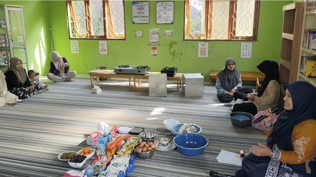 Owner Dapur H5H Desa Sungai Rukam I, Halimah, memberikan arahan kepada peserta saat praktik pembuatan pie buah dalam kegiatan Pustaka BISA di Perpustakaan Desa Sungai Rukam I.